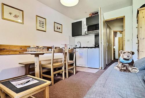 un chien assis à même le sol dans un salon dans l'établissement Résidence Divaria - Studio 4 personnes à Tignes au pied des pistes et proche des commerces dans le quartier du Lac. MAE-2136, à Tignes