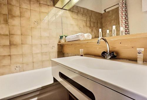 une salle de bain avec un lavabo et une baignoire dans l'établissement Résidence Divaria - Studio 4 personnes à Tignes au pied des pistes et proche des commerces dans le quartier du Lac. MAE-2136, à Tignes