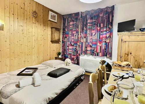 - une chambre avec un lit et une table avec deux chaises dans l'établissement Résidence Divaria - Studio 4 personnes à Tignes au pied des pistes et proche des commerces dans le quartier du Lac. MAE-2136, à Tignes