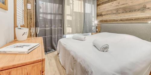 - une chambre avec un lit blanc et une table en bois dans l'établissement Résidence Hameaux De Toviere - Terrasse de 35m², un emplacement unique à TIGNES MAE-2591, à Tignes