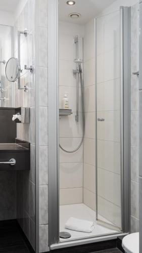 a shower with a glass door in a bathroom at Hotel Kreuzer in Wedel