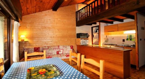 une salle à manger avec une table et une cuisine dans l'établissement Résidence Ancolie - Les Hauts De Planchamp - 2 Pièces pour 5 Personnes MAE-3335, à Champagny-en-Vanoise