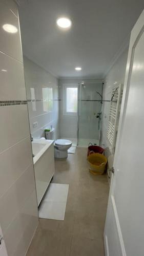 a white bathroom with a toilet and a sink at Family-friendly Beach Escape- 130m2 of pure joy in Port de Pollensa
