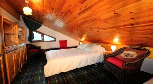 ein Schlafzimmer mit einem Bett und einem Stuhl in einem Zimmer in der Unterkunft Résidence BruyÈres - Les Hauts De Planchamp - 3 Pièces pour 6 Personnes MAE-3322 in Champagny-en-Vanoise