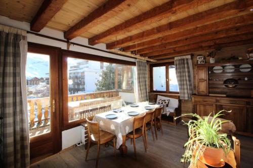 d'une salle à manger avec une table et quelques fenêtres. dans l'établissement Chalet Bobech - Chalet traditionnel décor bois, très chaleureux et convivial. MAE-3379, à Tignes