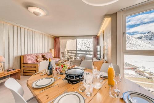 une salle à manger avec une table avec des assiettes et des verres à vin dans l'établissement Résidence Palafour - 3 pièces renové 3 - familial, spacieux - 2 salle de bain/douche - balcon vue lac MAE-3381, à Tignes