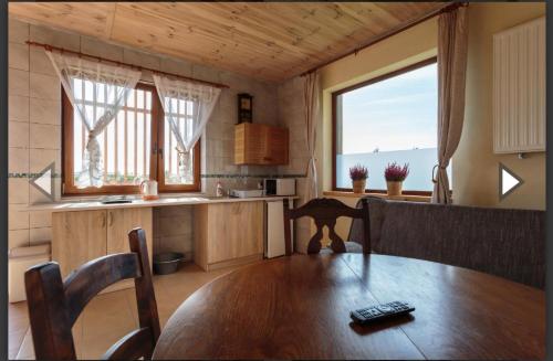 a kitchen and dining room with a table and window at SoCloseBeach Apartament Chłopy in Chłopy