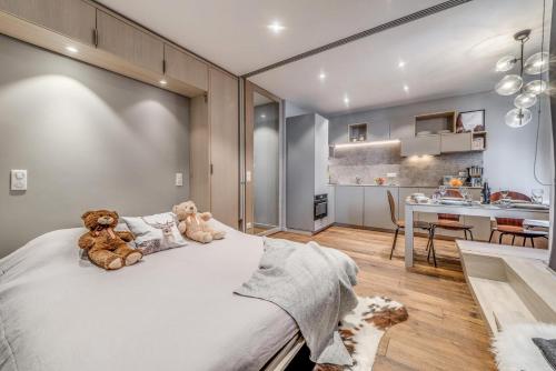 - une chambre avec deux ours en peluche assis sur un lit dans l'établissement Résidence Combe Folle - Appartement rénové 3 - Terrasse - vue lac MAE-3384, à Tignes