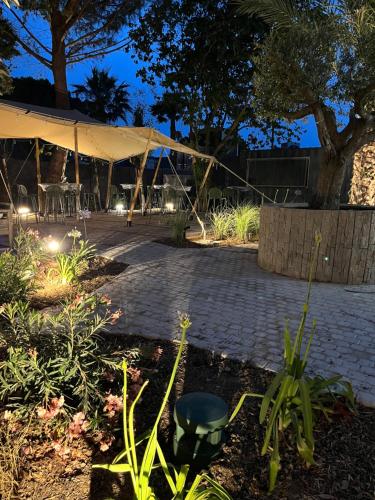 a patio with a tent with a table and chairs at Hôtel Le Relais des Brasseurs - Aubagne in Aubagne