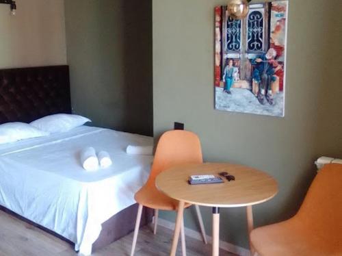 a bedroom with a bed and a table next to a bed at Avilion Apartments Anj 6 3 in Tbilisi City