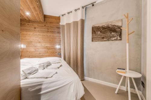 Cette petite chambre comprend un lit blanc et un tabouret. dans l'établissement Résidence RÉsidence 2100 B - 2 pièces 4 entièrement rénové 3 MAE-3387, à Tignes
