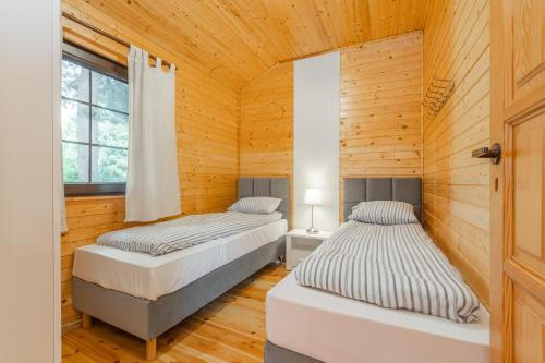 Postel nebo postele na pokoji v ubytování Bryza Jantar apartamenty z sauną & domki z kominkami