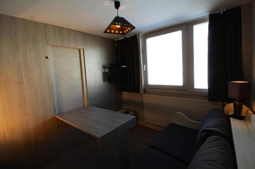 une chambre avec un canapé, une table et une fenêtre dans l'établissement Résidence Palafour - Studio 2 - Rénové, confortable - nord vue montagne MAE-3402, à Tignes