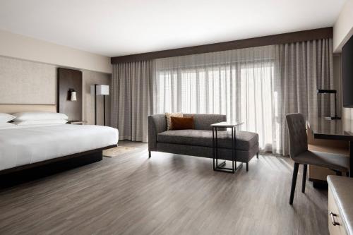 a hotel room with a bed and a chair at Marriott Riverside at the Convention Center in Riverside