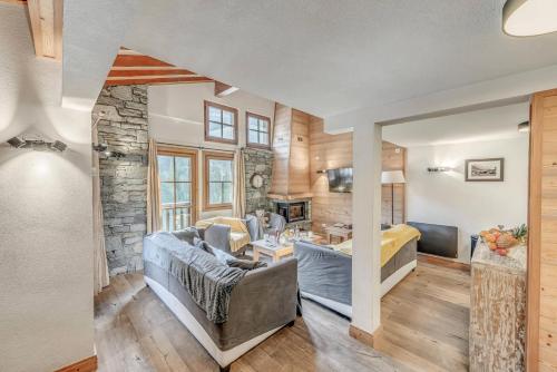 un salon avec un mur en pierre dans l'établissement Chalet Crystal Ridge - Chalet - 129m2 - 6 chambres, 6 salles de bain MAE-3406, à Les Boisses