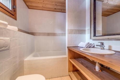 une salle de bain avec un lavabo et une baignoire dans l'établissement Chalet Crystal Ridge - Chalet - 129m2 - 6 chambres, 6 salles de bain MAE-3406, à Les Boisses
