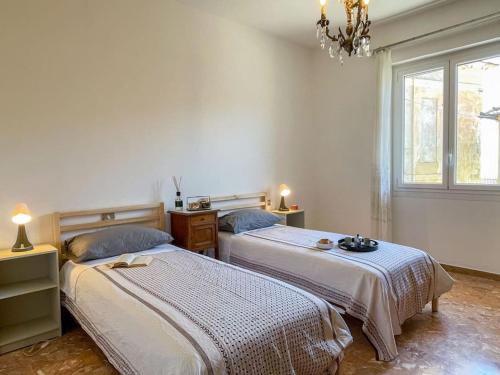 a bedroom with two beds and a chandelier at Panoramica sul Terrazzo in Villa Talla
