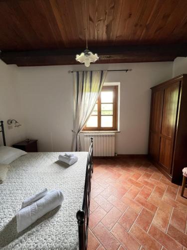 a bedroom with a bed and a window at Agriturismo Melodie Toscane Sorano in Sorano