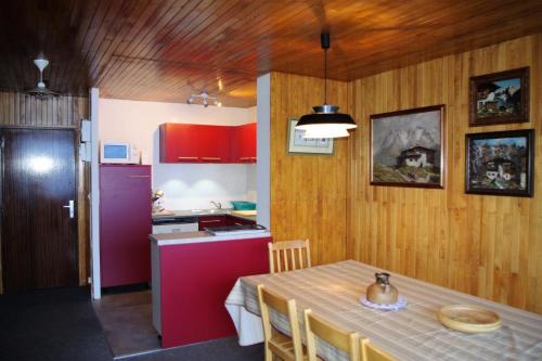 une cuisine avec une table et une cuisine avec des placards rouges dans l'établissement Résidence PrÉmou - 3 pièces 70m2 belle vue lac et Grande Motte MAE-3423, à Tignes