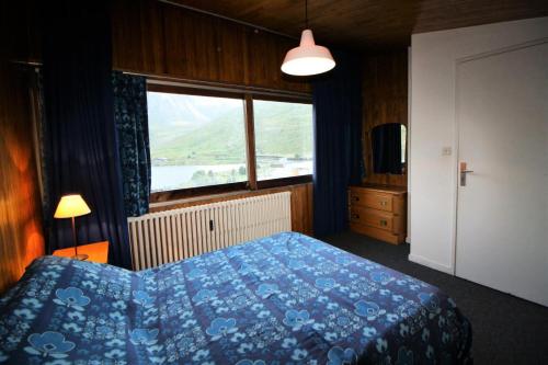une chambre avec un lit bleu et une fenêtre dans l'établissement Résidence PrÉmou - 3 pièces 70m2 belle vue lac et Grande Motte MAE-3423, à Tignes