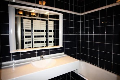 La salle de bains est pourvue de carrelage noir, d'un lavabo et d'une fenêtre. dans l'établissement Résidence PrÉmou - 3 pièces 70m2 belle vue lac et Grande Motte MAE-3423, à Tignes