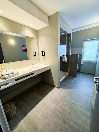 a bathroom with a sink and a mirror at Hôtel Panorama - Vue exceptionnelle sur la Semois in Bouillon