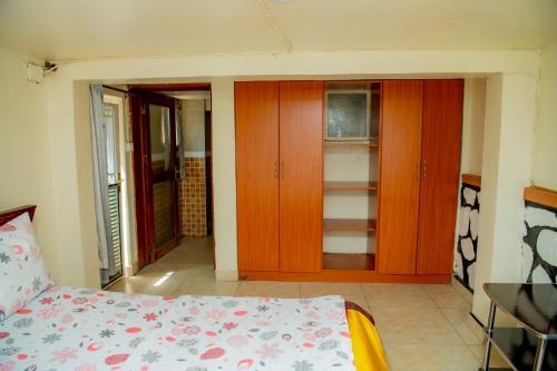 a bedroom with a bed and some wooden cabinets at Fleur Guest House in Kigali