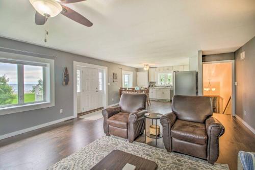 a living room with two chairs and a refrigerator at Modern Home on Mille Lacs Lake! Amazing yard and game-room! in Garrison