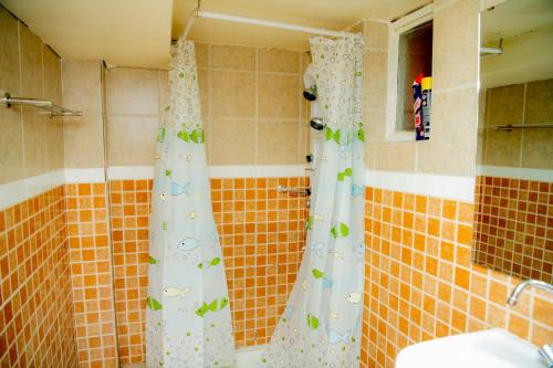a bathroom with a shower curtain with butterflies on it at Fleur Guest House in Kigali