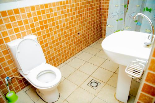 a bathroom with a toilet and a sink at Fleur Guest House in Kigali