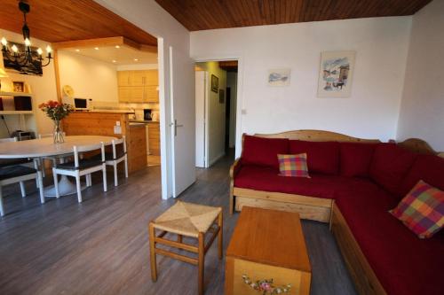 un salon avec un canapé rouge et une cuisine dans l'établissement Résidence Armaillis - Appartment familial, confortable, vue lac MAE-3427, à Tignes