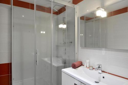 une salle de bain blanche avec une douche et un lavabo dans l'établissement Résidence Saint Jacques A - 3 Pièces pour 8 Personnes 32, à Mâcot La Plagne
