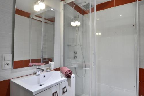 une salle de bain blanche avec un lavabo et une douche dans l'établissement Résidence Saint Jacques A - 3 Pièces pour 8 Personnes 34, à Mâcot La Plagne