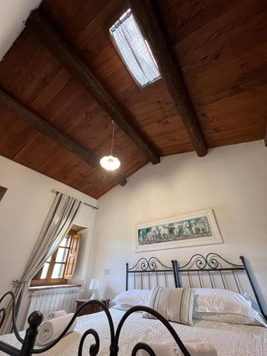 a bedroom with a bed in a room with wooden ceilings at Agriturismo Melodie Toscane Sorano in Sorano