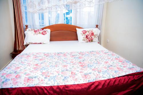 a bedroom with a large bed with a floral bedspread at Fleur Guest House in Kigali