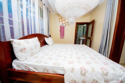 a bedroom with a bed with a white comforter at Fleur Guest House in Kigali