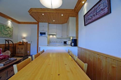 une salle à manger avec une table en bois et une cuisine dans l'établissement Résidence Bec Rouge - Vue lac, sur les pistes MAE-3448, à Tignes