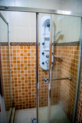 a bathroom with a shower with a toilet in it at Fleur Guest House in Kigali