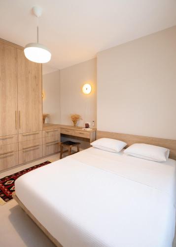 a bedroom with a large white bed and a desk at Seaside Residence in Vlorë