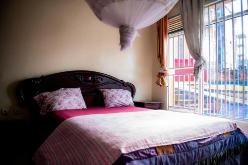 a bedroom with a bed and a large window at Fleur Guest House in Kigali