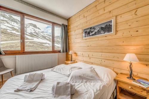 une chambre avec un lit et un mur en bois dans l'établissement Résidence Bec Rouge - Appartement rénové 3, ski au pied, vue lac MAE-3464, à Tignes