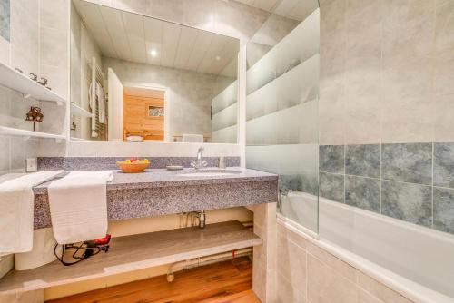 une salle de bain avec un lavabo et une baignoire dans l'établissement Résidence Bec Rouge - Appartement rénové 3, ski au pied, vue lac MAE-3464, à Tignes