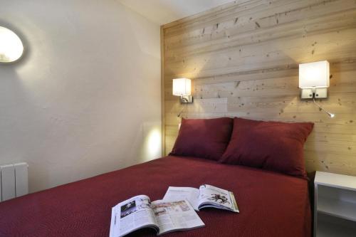 - une chambre avec un lit rouge et des journaux dans l'établissement Résidence Saint Jacques A - 2 Pièces pour 5 Personnes 63, à Mâcot La Plagne