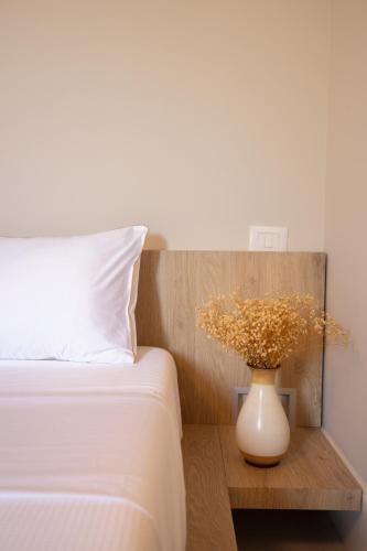 a white vase on a table next to a bed at Seaside Residence in Vlorë