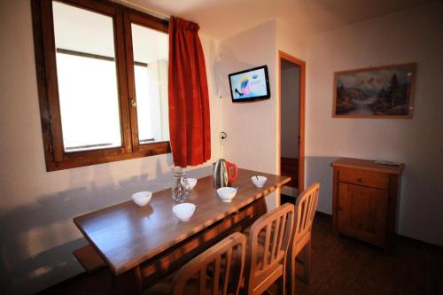 une salle à manger avec une table en bois et une fenêtre dans l'établissement Résidence Rond Point Des Pistes - proximité immédiate des pistes et des remontées mécaniques (Funiculaire) MAE-3472, à Tignes