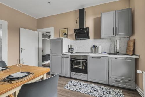a kitchen with stainless steel appliances and a wooden table at HIRSCH Apartment Luchs - zentral - modern - groß in Bad Harzburg