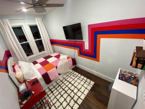 a bedroom with a bed and a colorful wall at Heart of NY - 17 min to Empire State & Times Sq in Jersey City