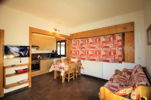 a living room with a table and a kitchen at Chalet De La Tour - entièrement rénové et confortable MAE-3503 in Tignes