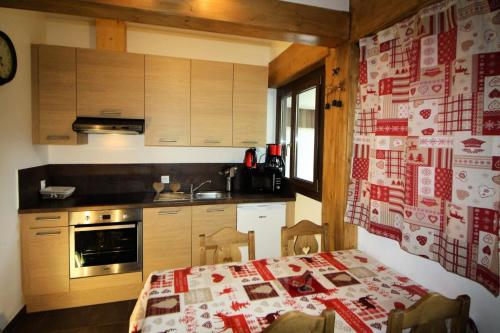 a kitchen with a table with a red and white quilt at Chalet De La Tour - entièrement rénové et confortable MAE-3503 in Tignes