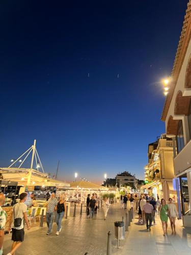 a group of people walking on a boardwalk at night at Piso a 15 minutos Port Aventura. in Cambrils